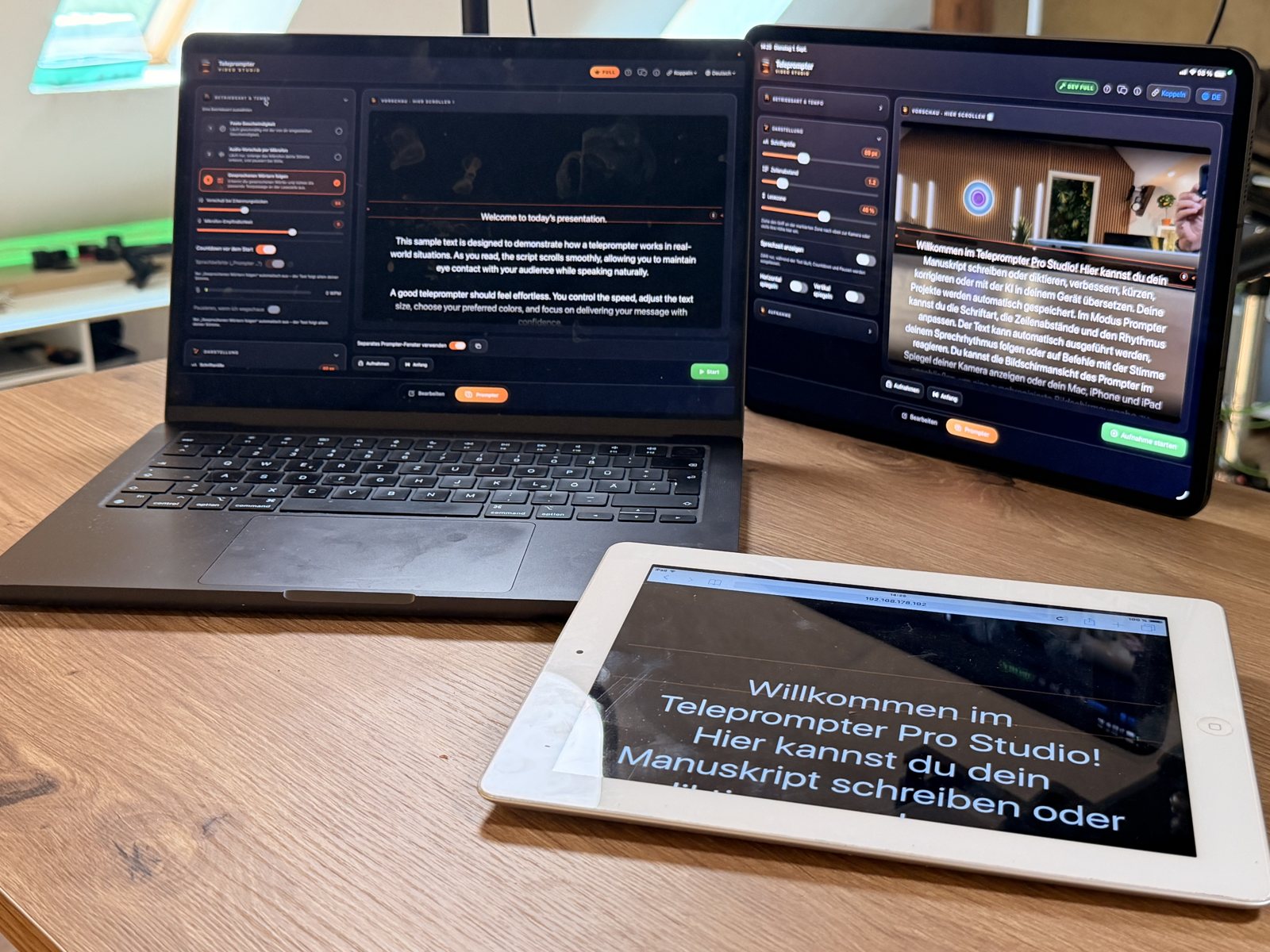 An older white iPad lies in front of a MacBook and an iPad and shows the prompter text